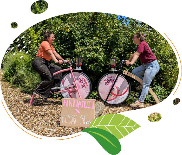 Deux personnes pédalant sur des vélos smoothies personnalisés Octobre Rose